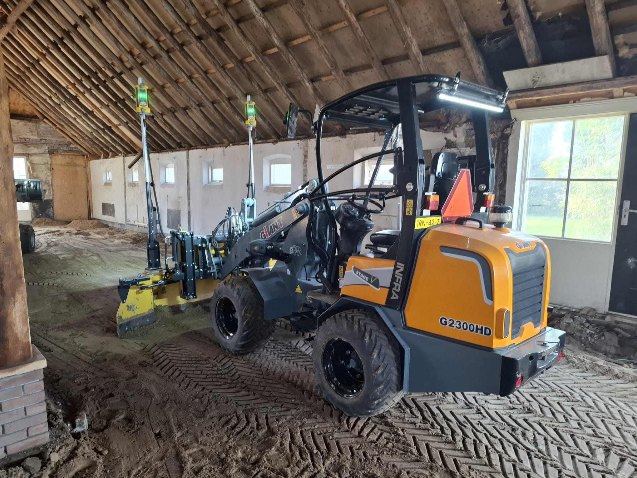 Minishovel met levelbak bij indoor werkzaamheden